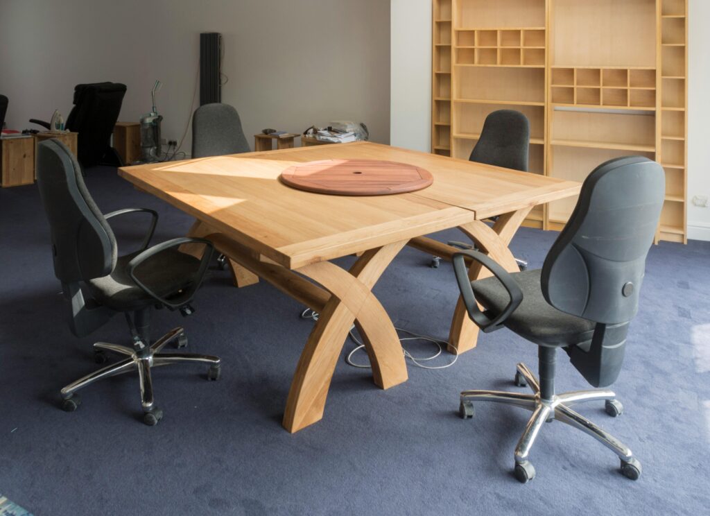 Contemporary office meeting room featuring a unique wooden table design and ergonomic chairs.