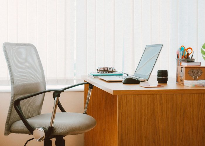 A tranquil modern home office featuring a wooden desk, ergonomic chair, and soft natural light.