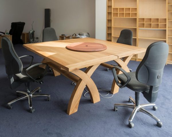 Contemporary office meeting room featuring a unique wooden table design and ergonomic chairs.